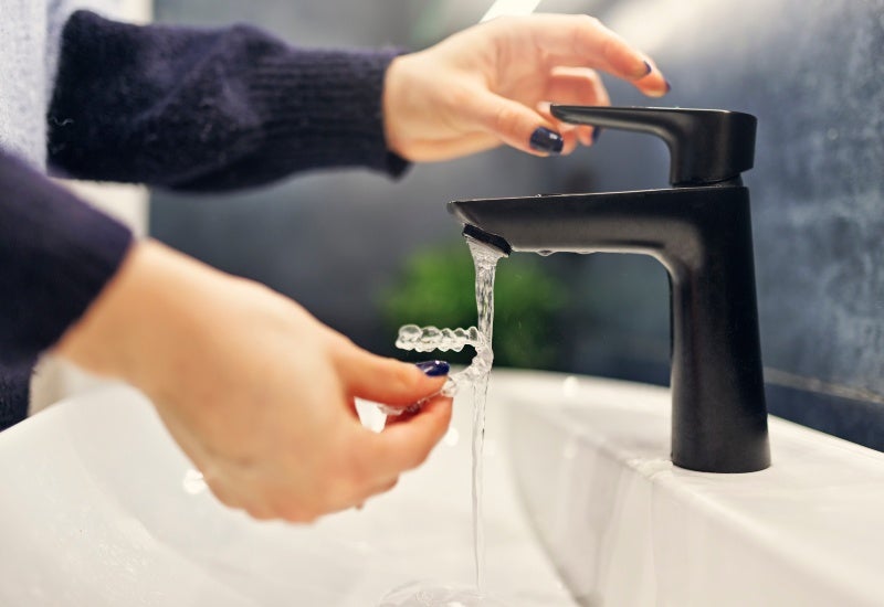 Woman cleaning dental braces in Fairfax, VA
