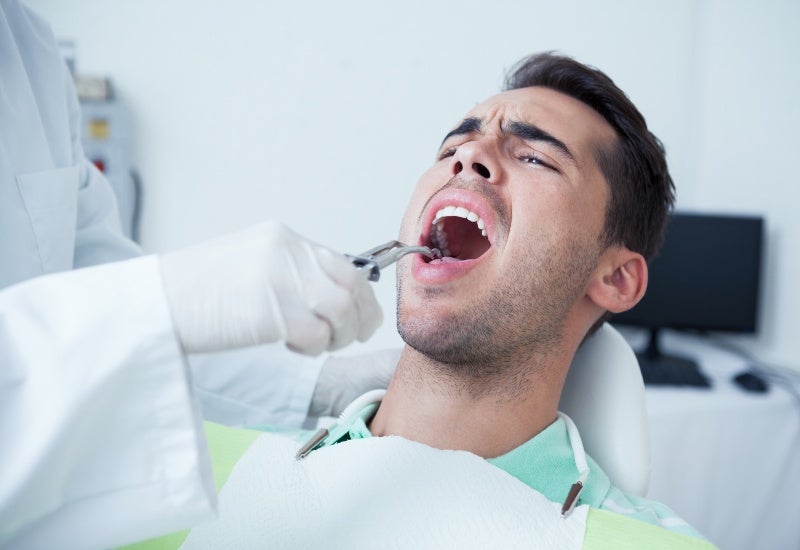 Close-up of a man having his teeth examined by a dentist in Fairfax, VA.